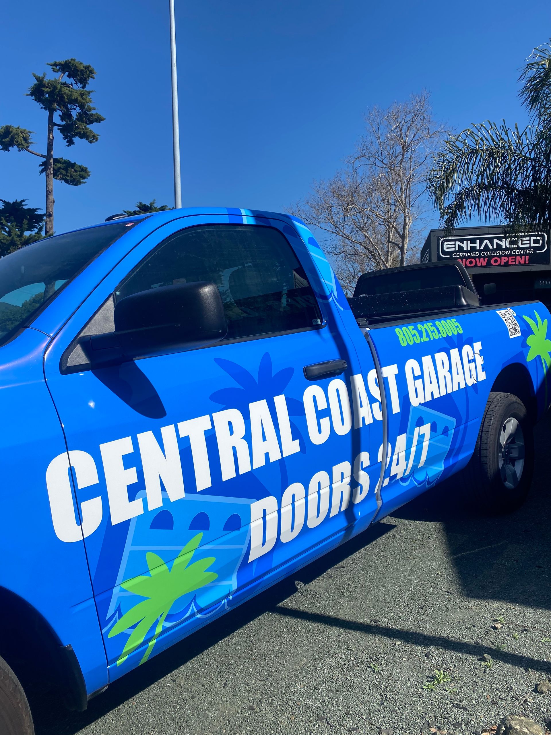 Blue Central Coast Carriers truck with green palm logo parked outdoors under a clear sky