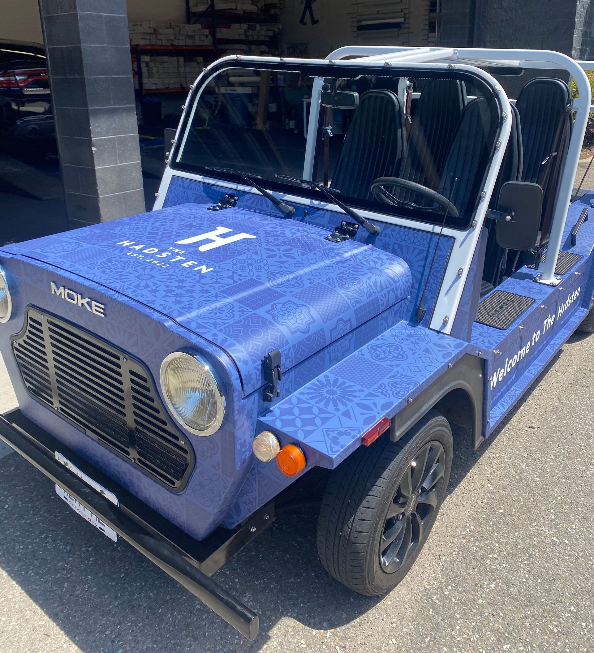 Blue vintage off-road vehicle with roll cage and black wheels parked outdoors