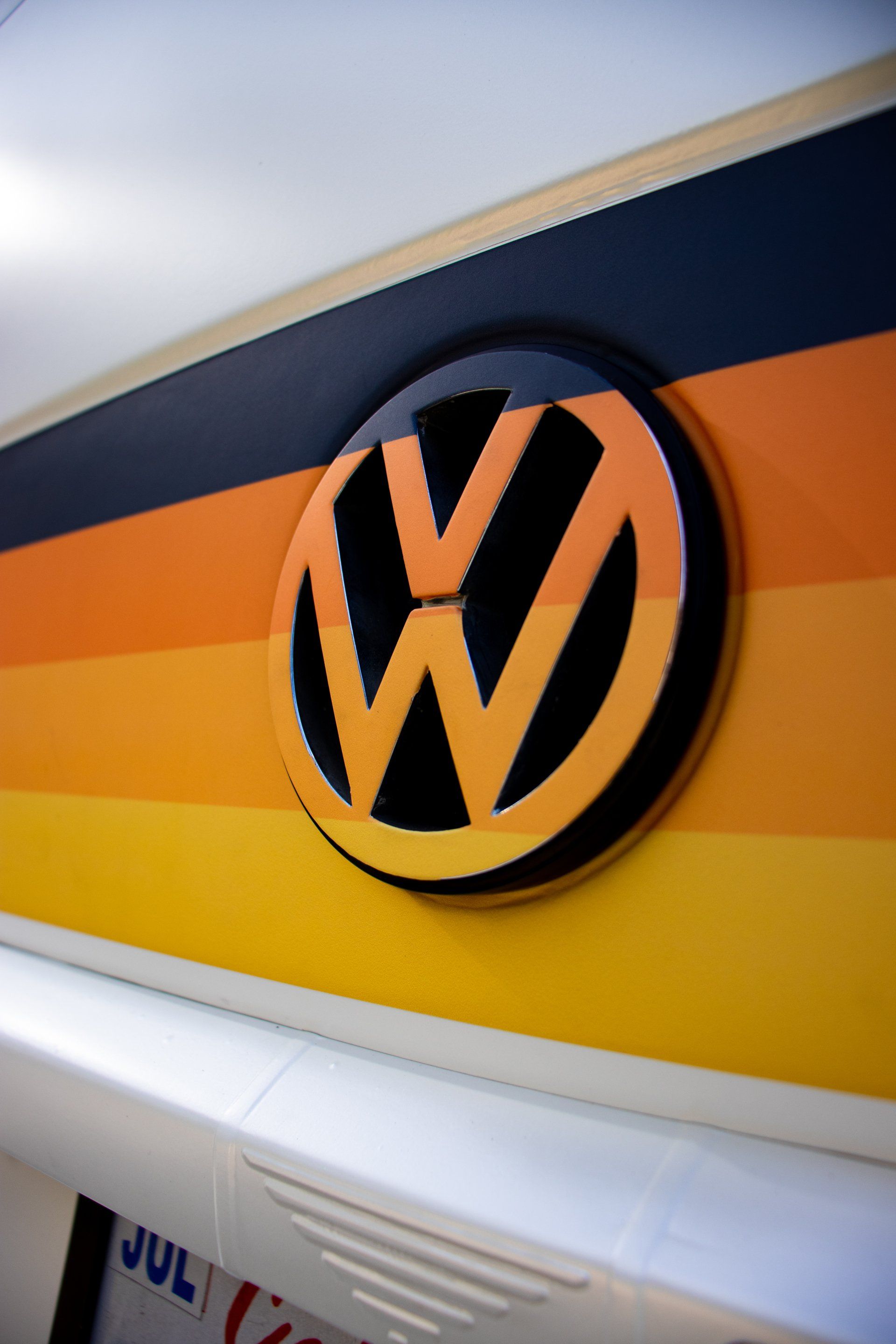 Volkswagen logo on a black, orange, and yellow striped wall panel