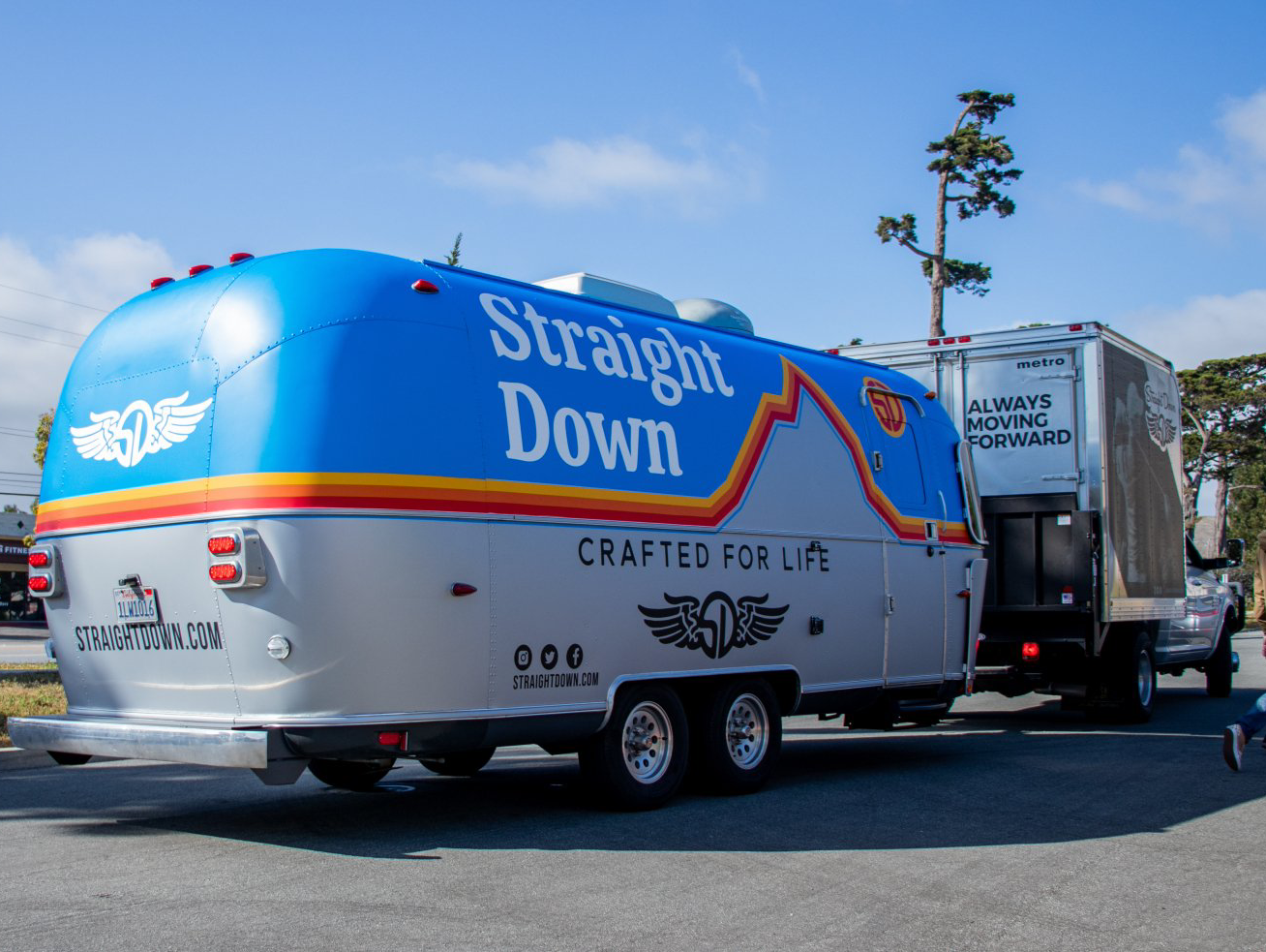 Silver Straight Down trailer truck parked outdoors under a blue sky