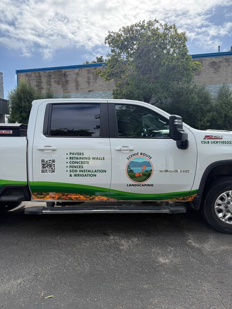 White pickup truck with city logo and contact info parked outdoors by a building.