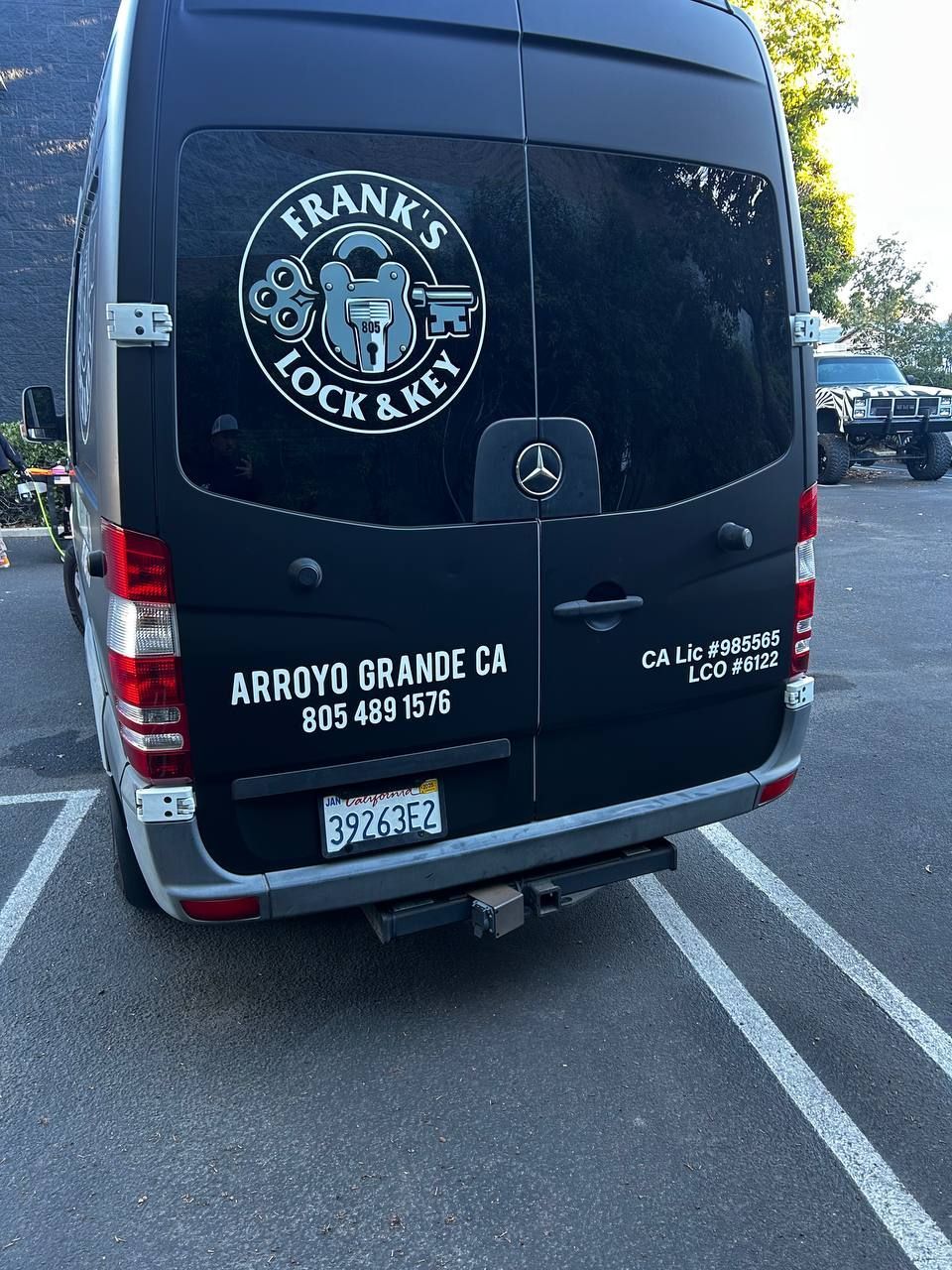 Black cargo van with Frank's Lock & Key logo parked in a lot.