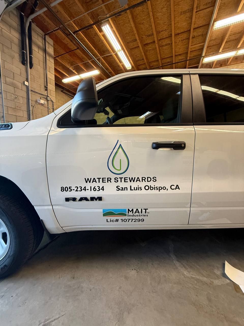 White Water Stewards pickup truck with company logos parked inside a warehouse.