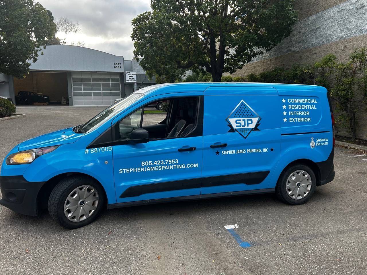 Blue service van parked in a lot, labeled with white company text and logo.