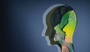 Silhouettes of three layered heads; inside, colors like green and yellow appear.