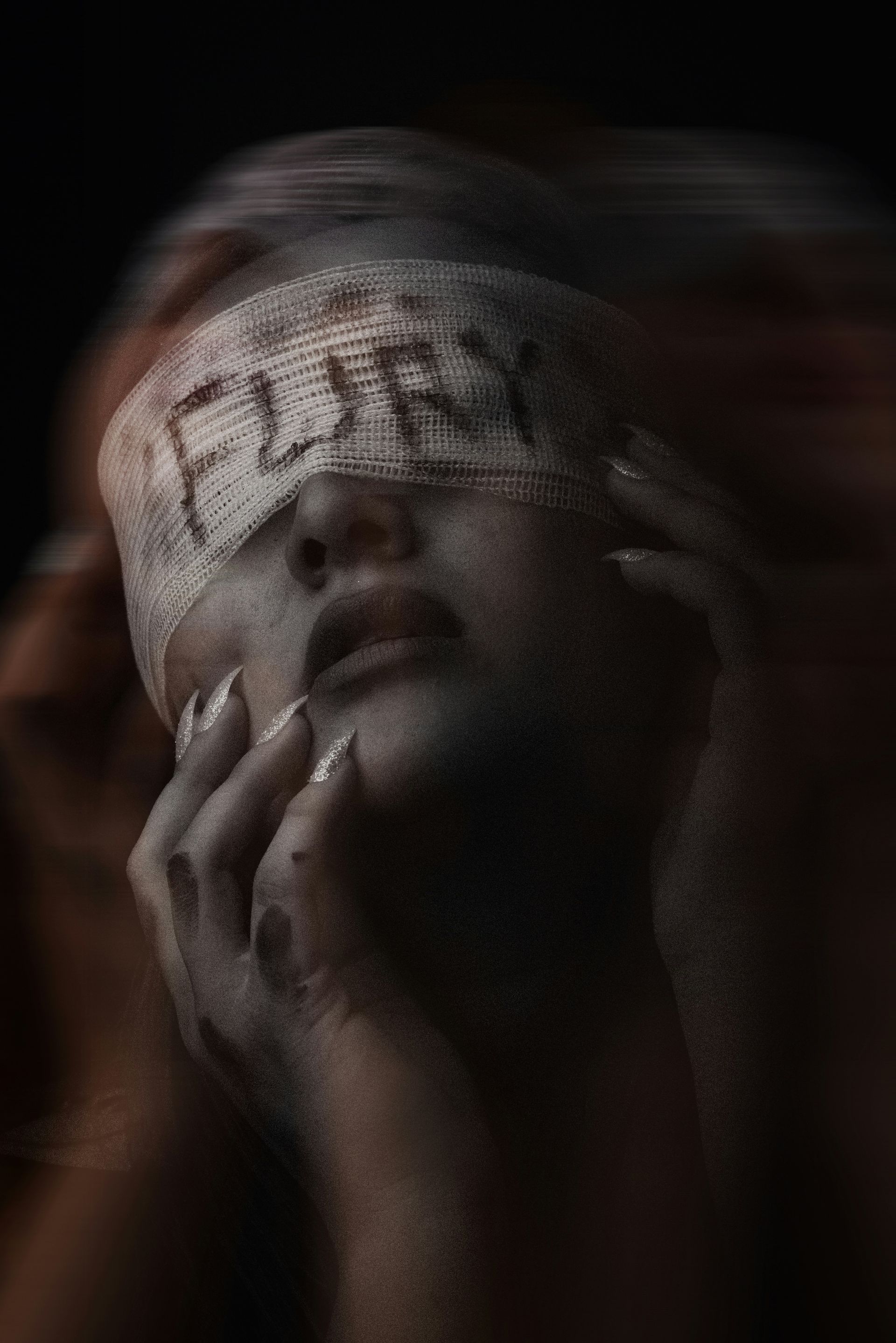Close-up of a face wrapped in gauze, with the word “FURY” written across the forehead.