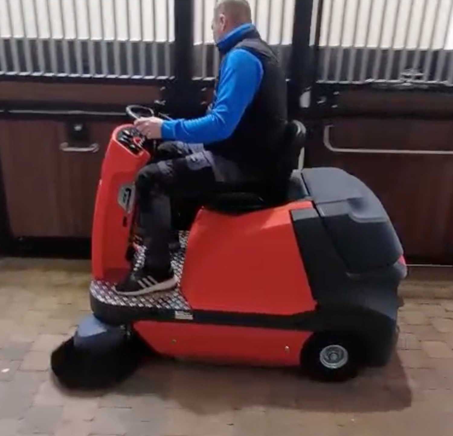 Meclean BUSTER 1150 Pro sweeping in horse stable aisle