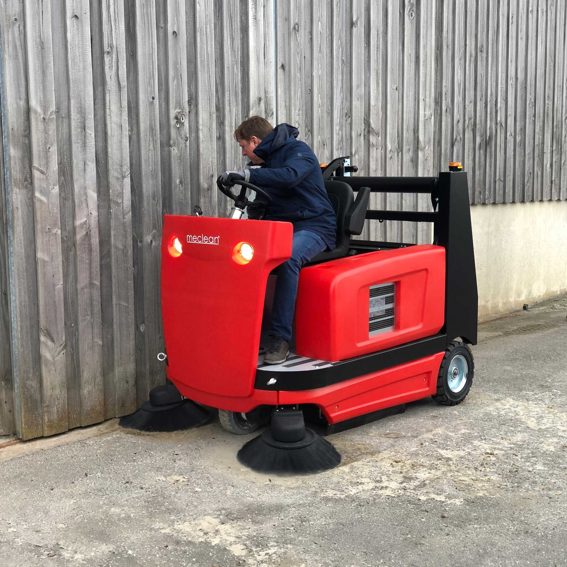 Meclean industriële veegmachine batterij aandrijving BUSTER 1300TTE vegen langs rand gebouw paardenmanege