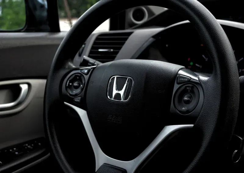 Close-up of a Honda steering wheel and dashboard inside a car interior