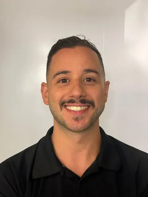 Smiling person in a black shirt against a plain white background