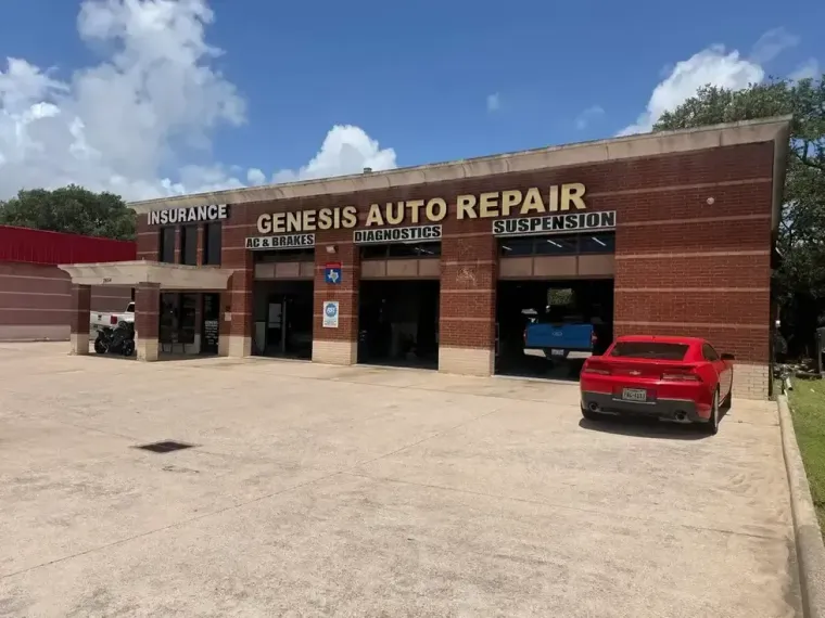 Two mechanics inspect a silver car in an auto repair shop in alvin texas with a lift and tools