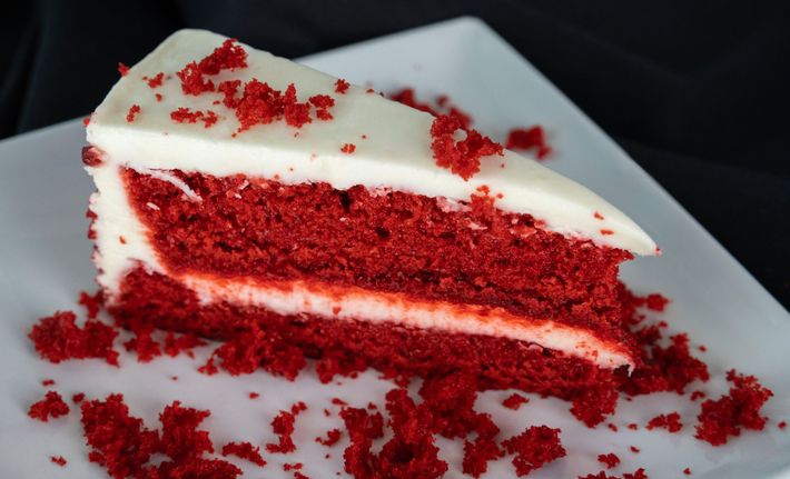 Thin slices of raw red meat on a white plate, arranged in overlapping layers
