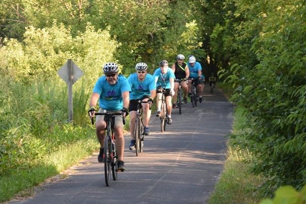A group of people are riding bicycles down a path.