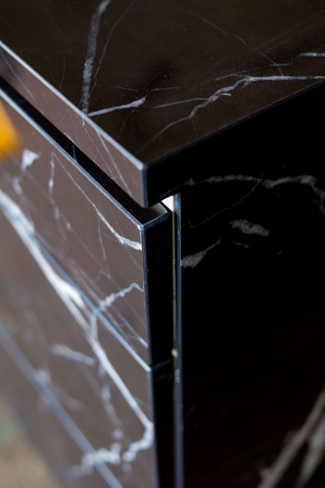 A close up of a black porcelain custom counter top with matching cabinetry.