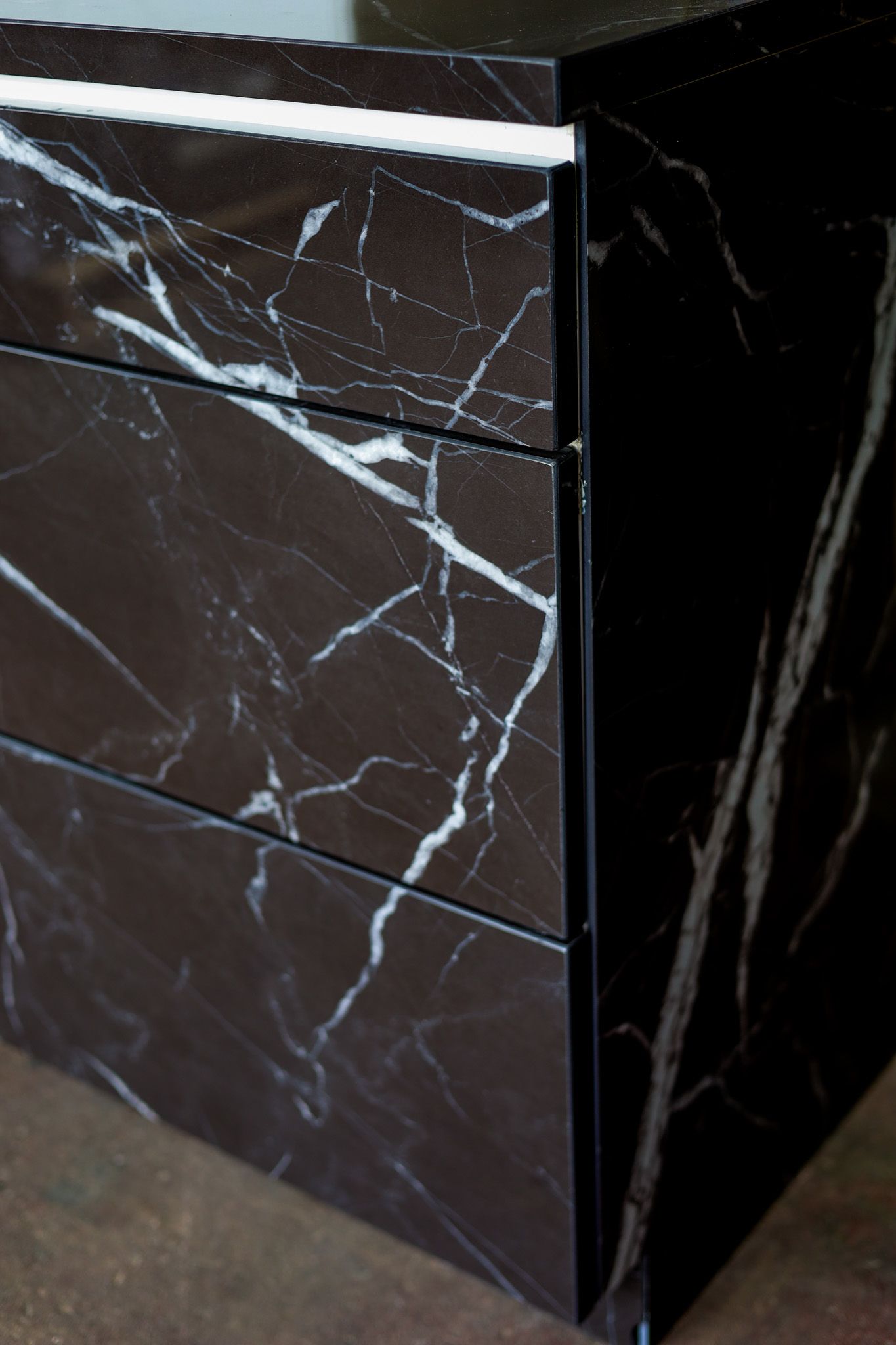A close up of a black and white custom porcelain cabinet with drawers.