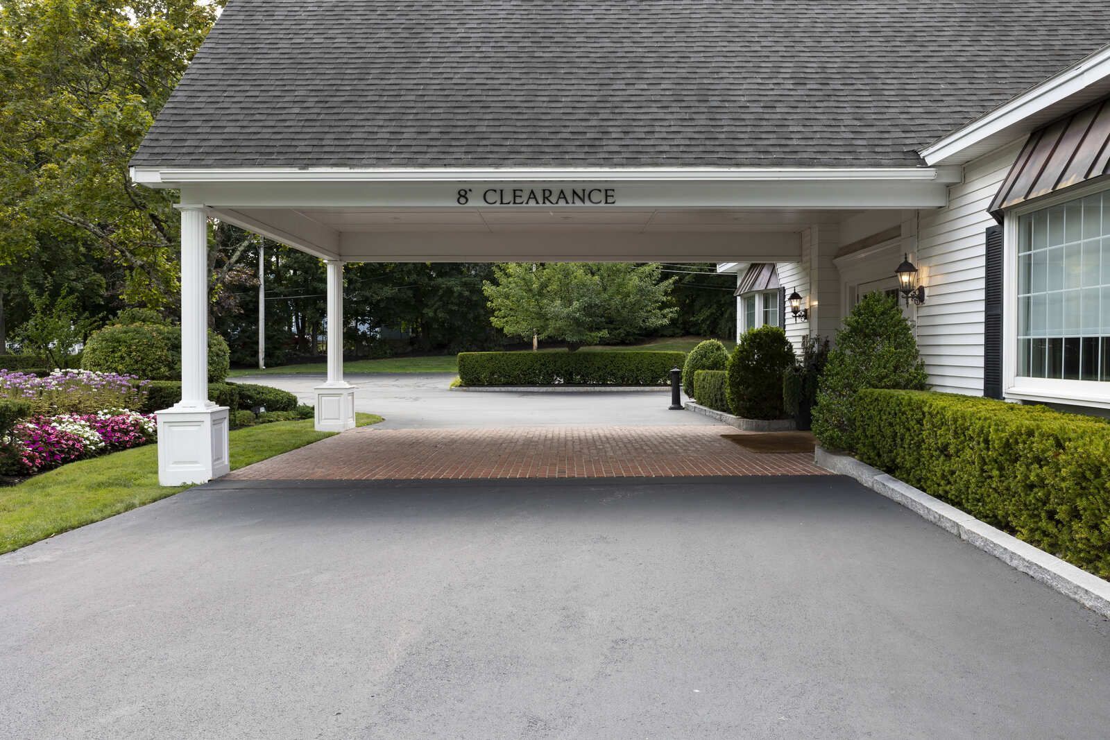 Entrance canopy labeled “8' CLEARANCE” over a driveway at a building entrance.