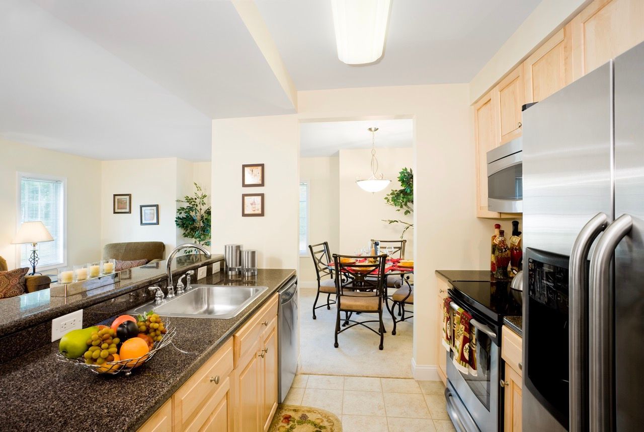 Open-concept kitchen with stainless appliances, view into dining and living area.