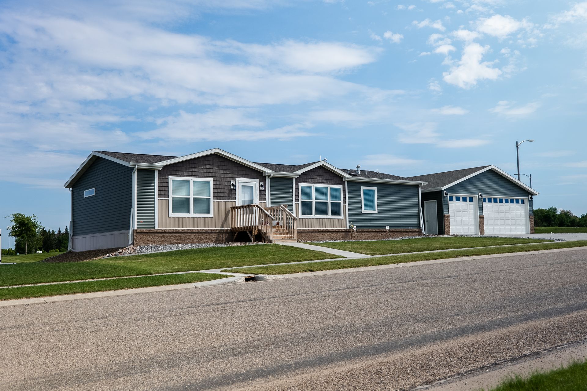 image of green and brown doublewide manufactured home with detached garage located in bismarck north dakot