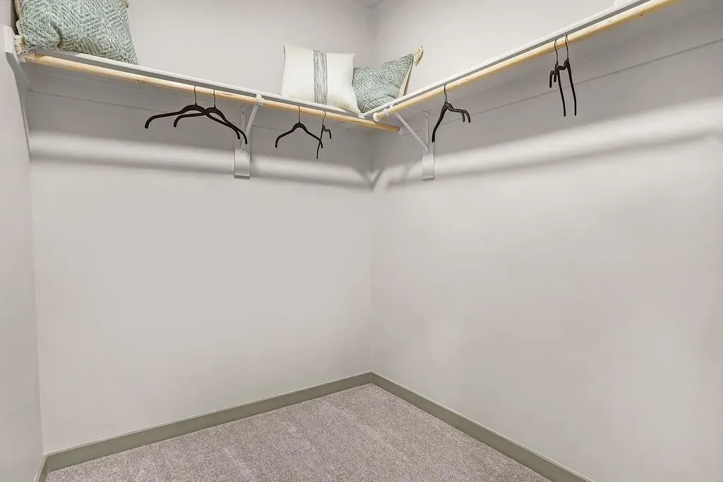Empty walk-in closet with shelving and hangers at Valley View, offering apartments in Magna, UT.