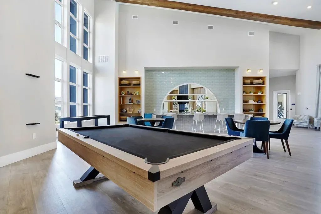 Billiard table and lounge area with bar and seating in a modern community clubhouse at Valley View, offering apartments in Magna, UT.