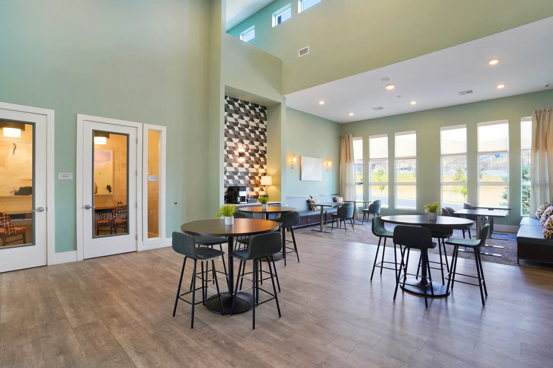 Modern community lounge area with high ceilings, ample seating, and large windows at Valley View, offering apartments in Magna, UT.