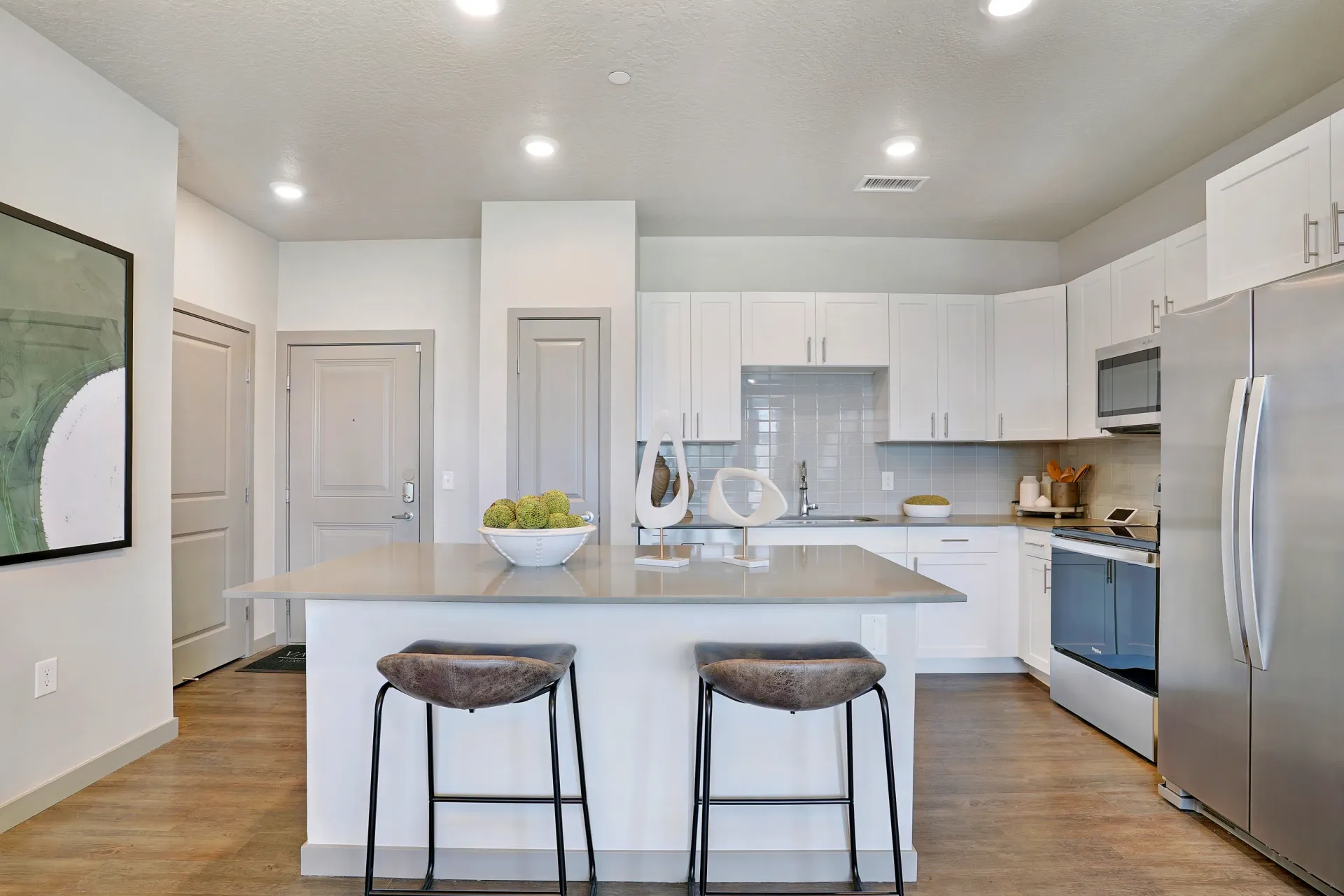Modern kitchen with island, stainless steel appliances, and white cabinets at Valley View, offering apartments in Magna, UT.