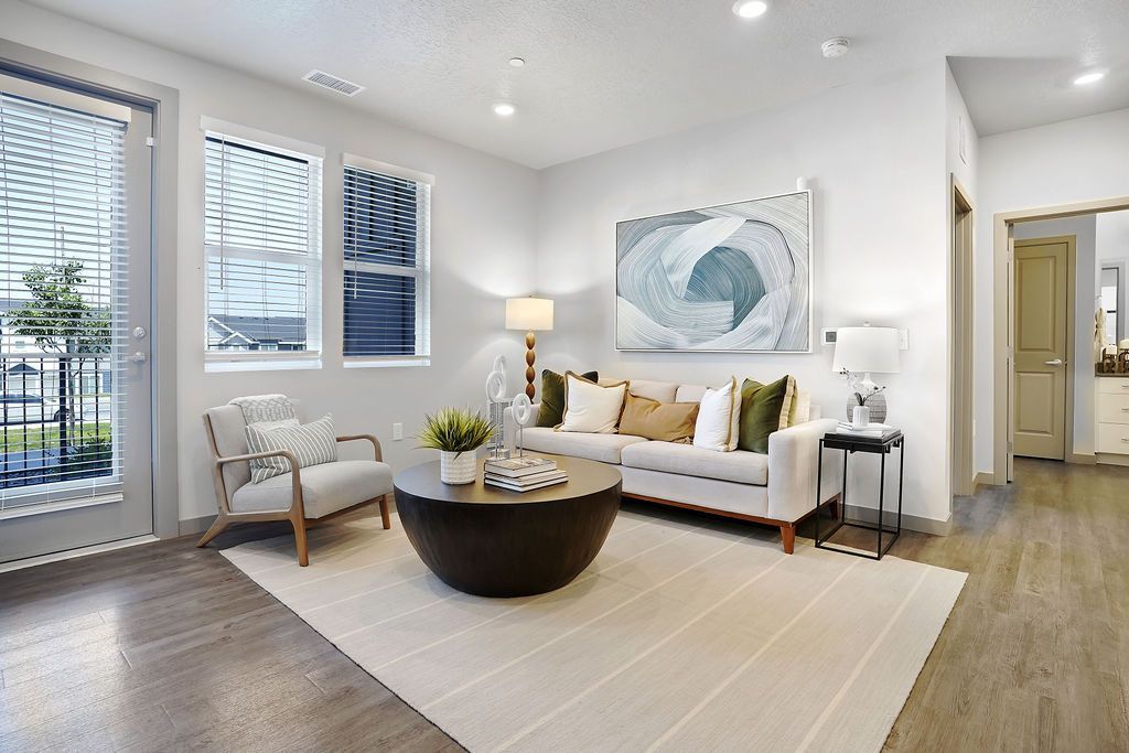 Living room with a sofa, armchair, coffee table, and large abstract wall art at Valley View, offering apartments in Magna, UT.