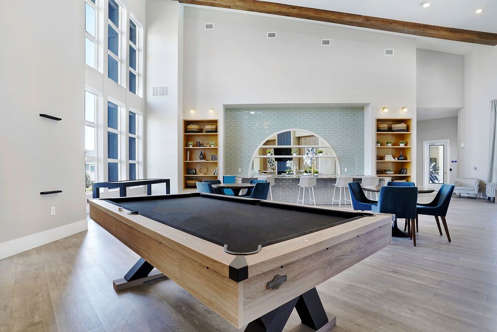 Billiards table in a bright modern community lounge with seating at Valley View, offering apartments in Magna, UT.
