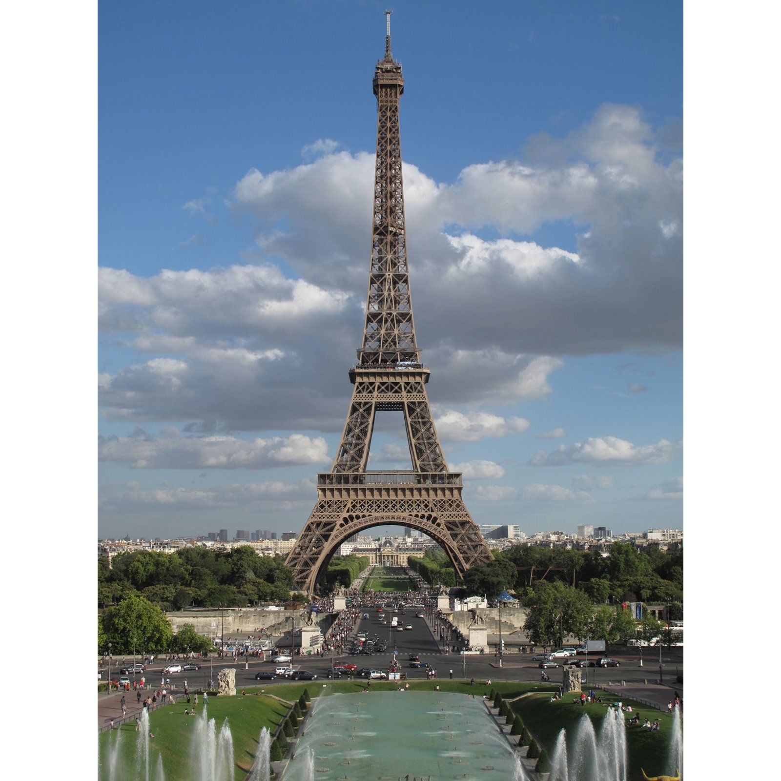 Eiffel Tower rising above a fountain and park in Paris under a partly cloudy blue sky
