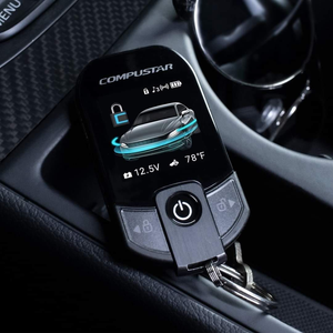 Compustar car remote on a car console, displaying lock icon, car graphic, and temperature.