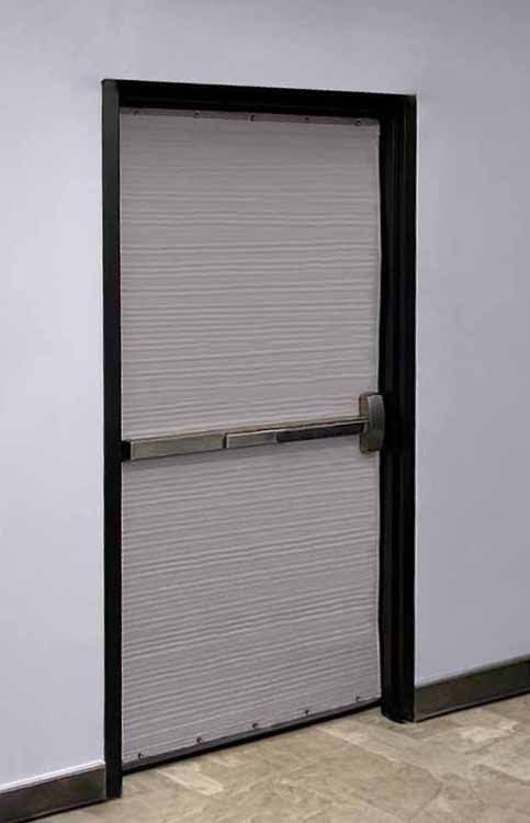 Closed gray metal door with horizontal push bar and black frame in a hallway