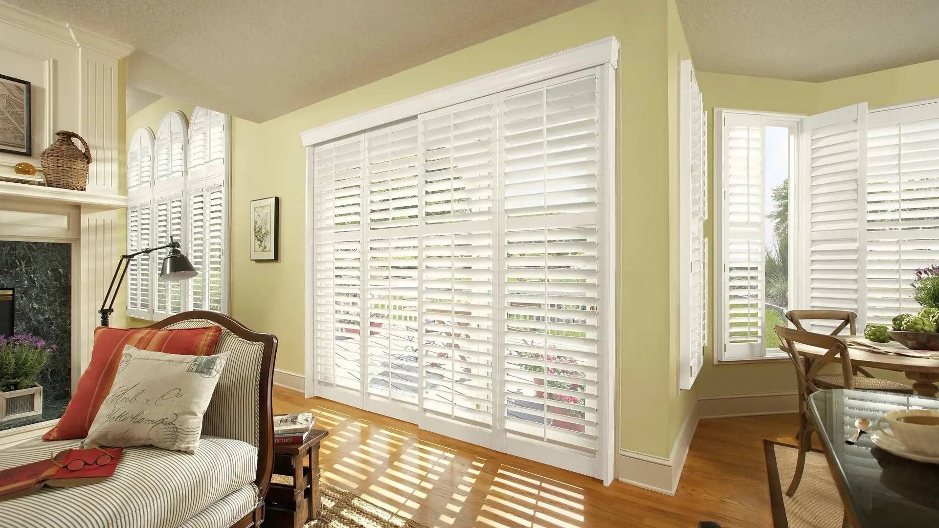 Alta Composite Shutters on multiple windows and a sliding glass door in a living room