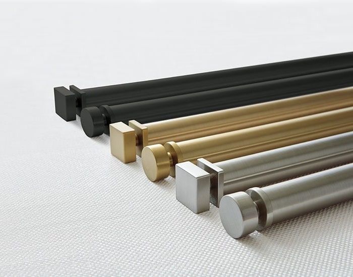 Four decorative curtain rods in black, gold, bronze, and silver on a light background