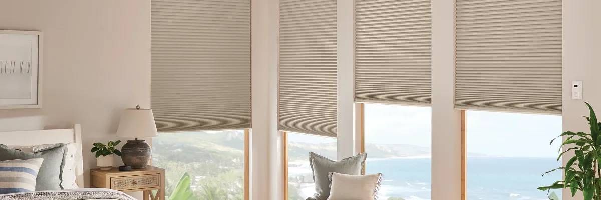 Graber® Cellular Shades in a stunning neutral color on bedroom windows, overlooking a body of water