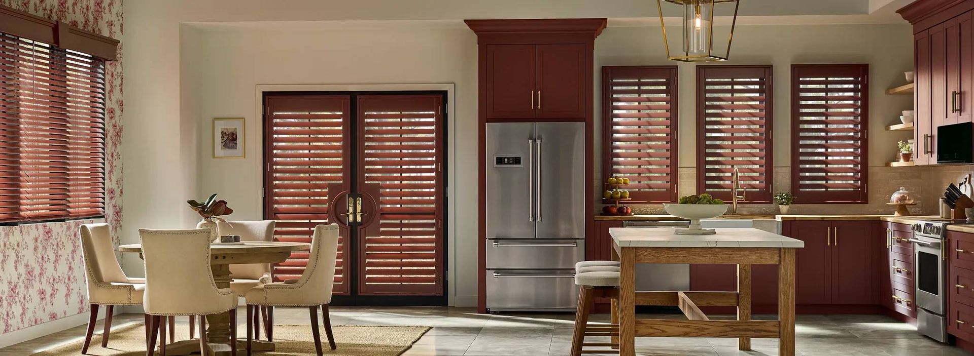 Graber® Wood Shutters on several windows and French doors in a warm-toned kitchen