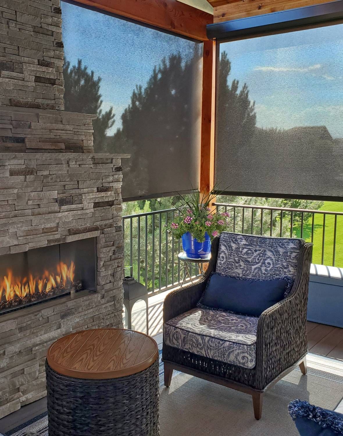 Insolroll Oasis® 2700 Patio Sun Shades in a home's sun room outside with fireplace