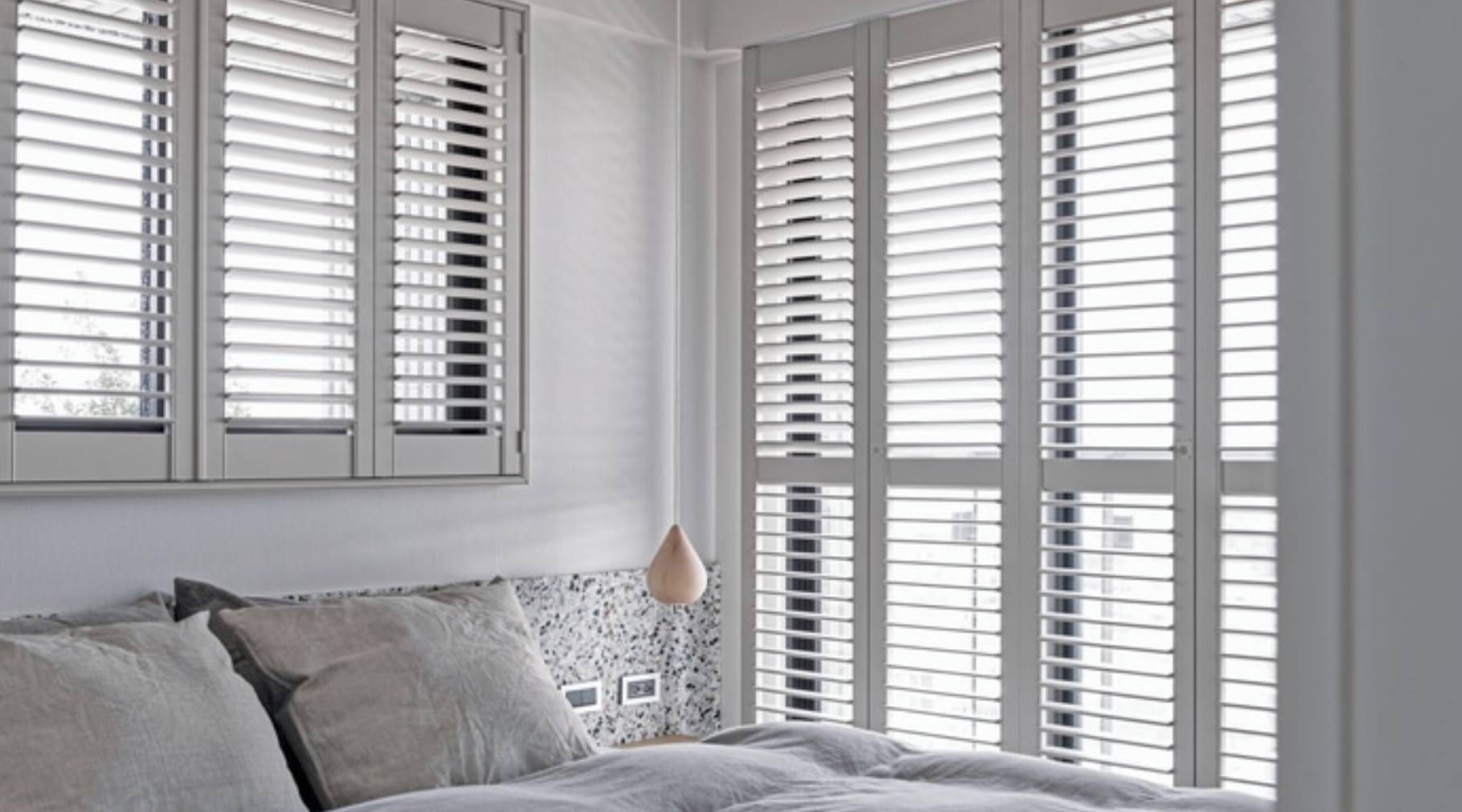 Norman® Brightwood™ Shutters on windows and a door in a bedroom with a gray theme