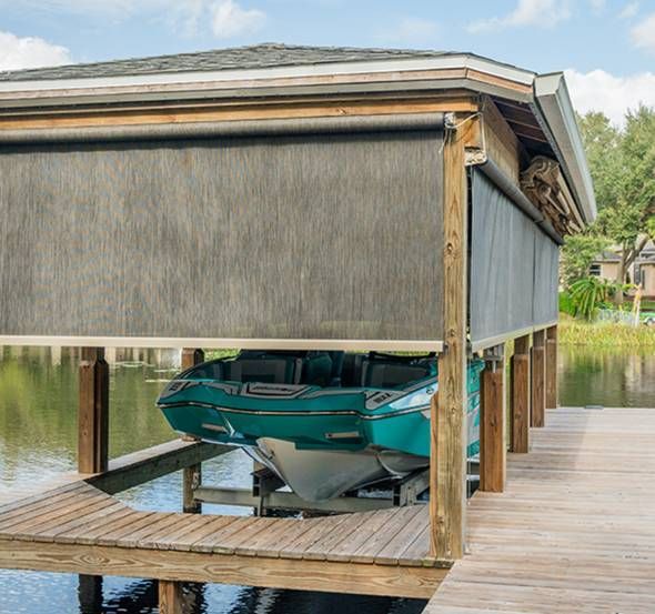 SunPro Open Roller Cable-Guided Motorized Screens on an outdoor structure to protect a boat