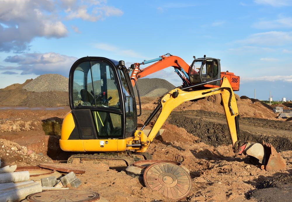 Yellow and Orange Excavator on a Construction Site — Macca's Dynamic Earthworks in Tolga, QLD