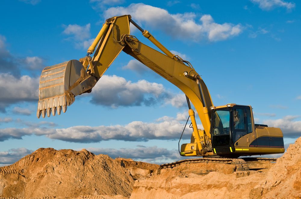 Yellow Excavator Digging in Brown Dirt — Macca's Dynamic Earthworks in Tolga, QLD