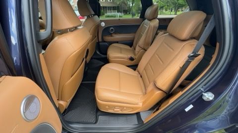 Tan leather seats inside a dark blue SUV with open rear door