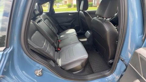 Blue car interior with rear seat folded down, viewed through the open side door