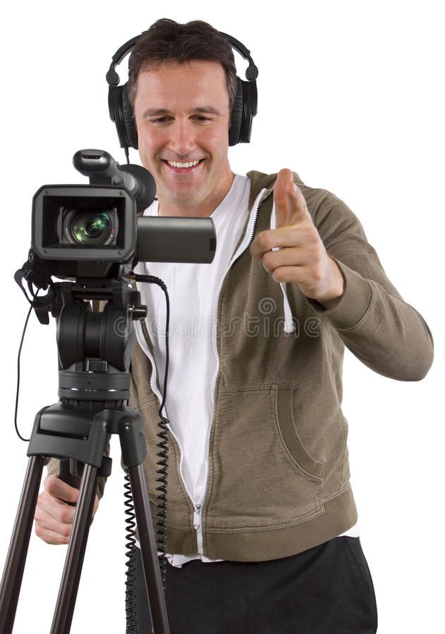 Een man lacht naast een videocamera en statief en steekt zijn duim omhoog terwijl hij een koptelefoon draagt.