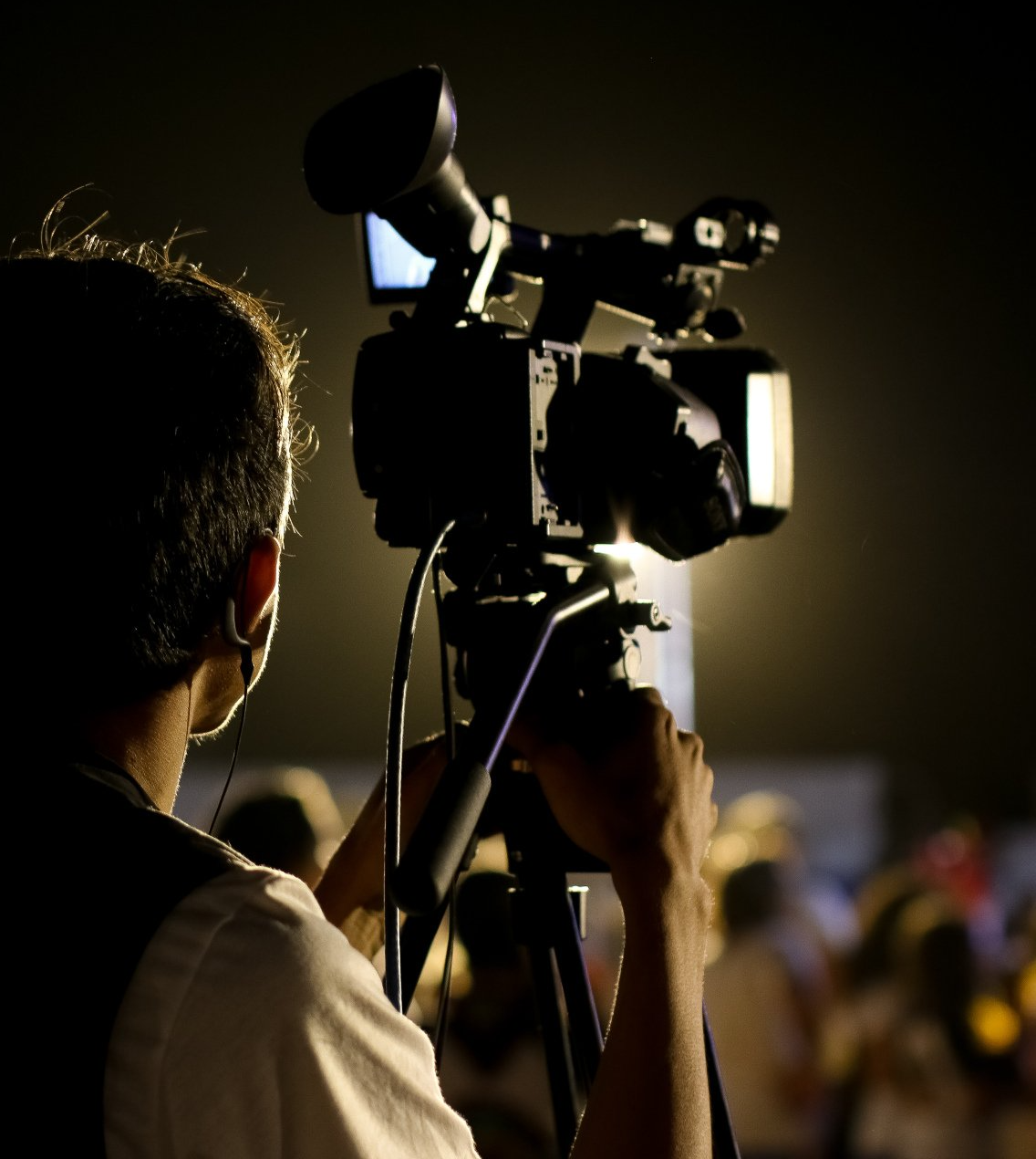 Cameraman filmt een menigte tijdens een evenement met weinig licht.