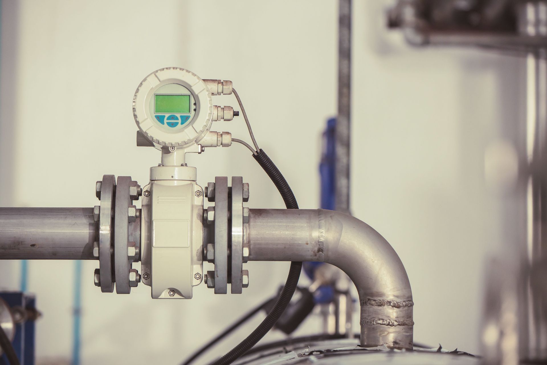 Industrial pipe with a digital flow meter and valve in a factory setting