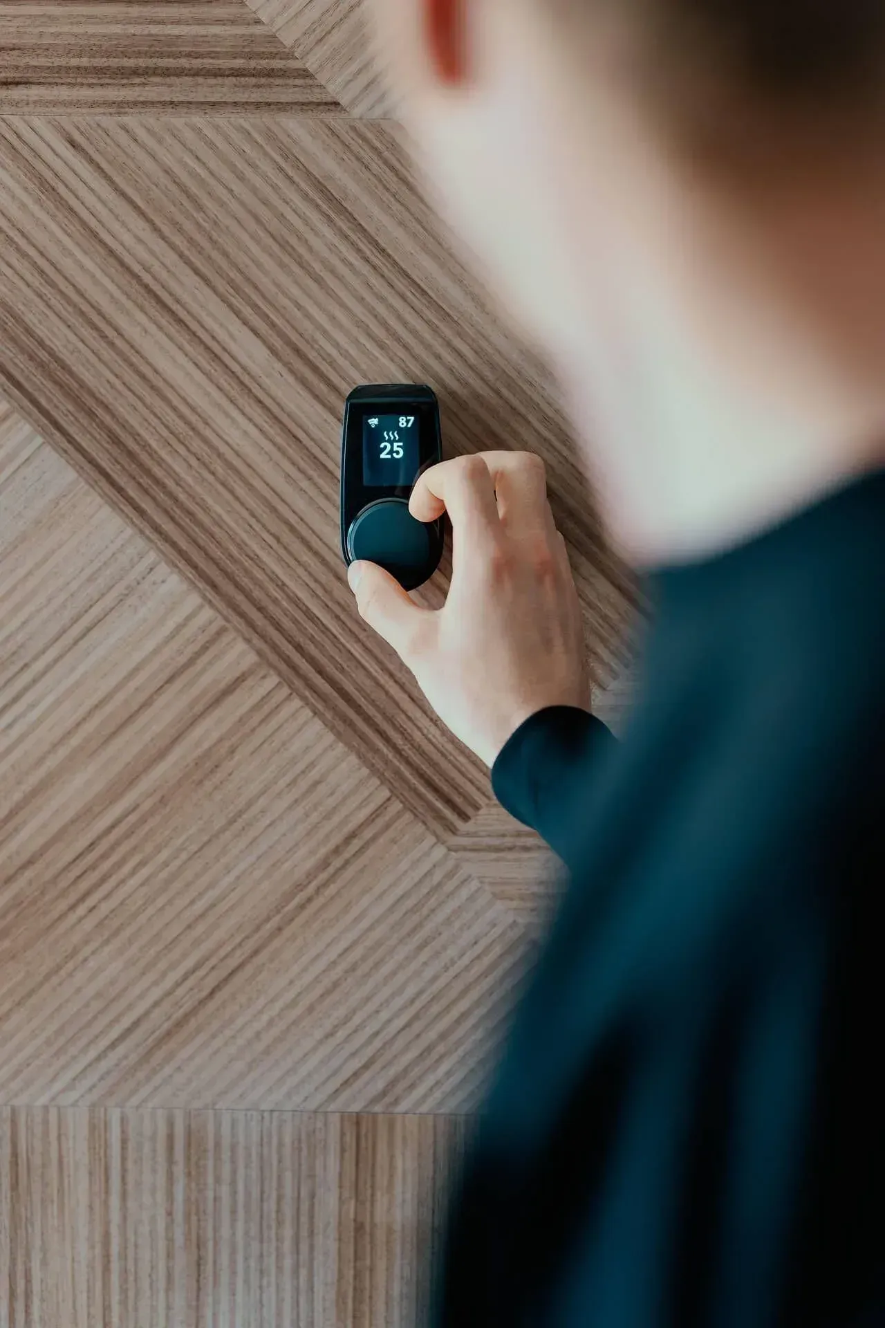 Person photographing a wooden geometric wall with a smartphone