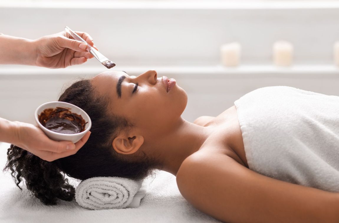 A woman is getting a facial treatment at a spa.