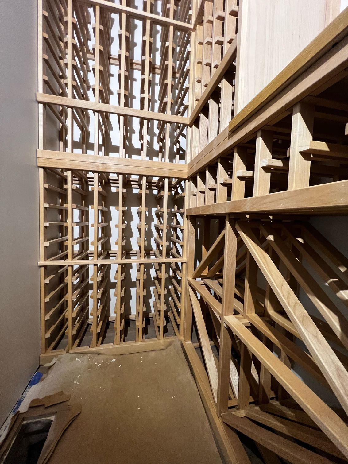 Wood-framed interior with stacked lattice panels and a narrow walkway, viewed from a stairwell.