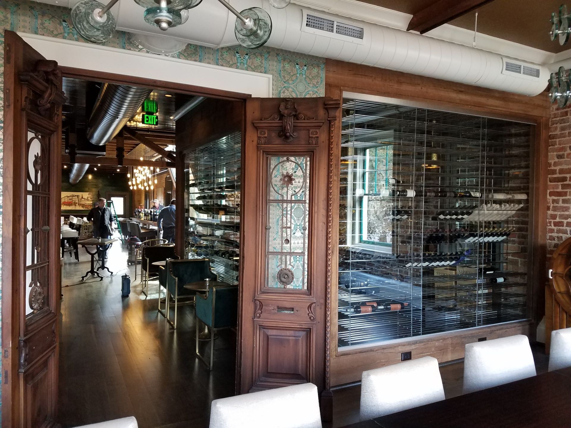 Interior of a rustic restaurant with wood decor, glass partition, and tables in the dining area