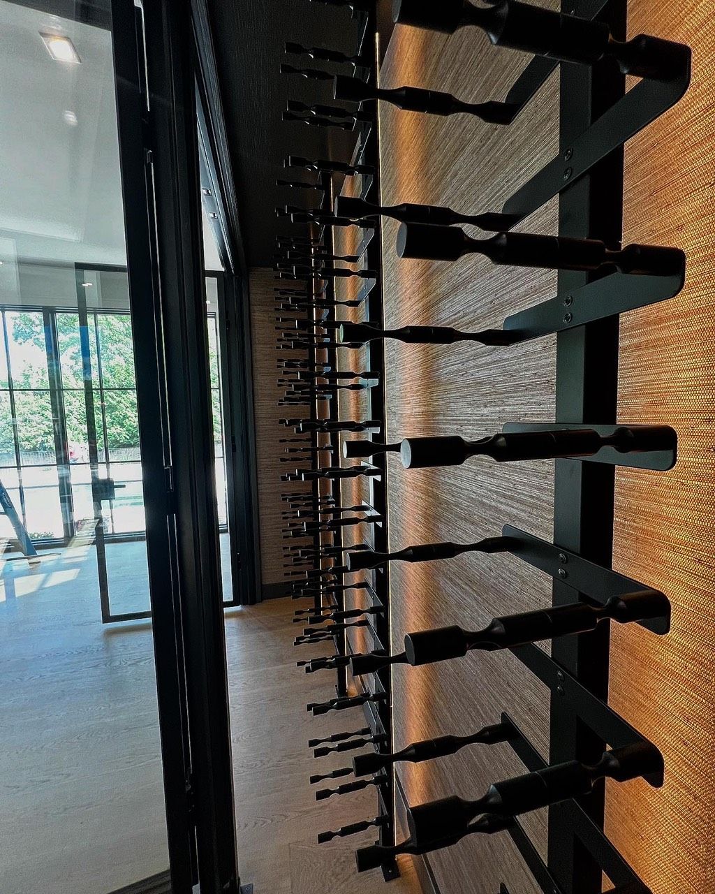 Modern lobby with a long row of black wall-mounted sculptures and a bright glass entrance.